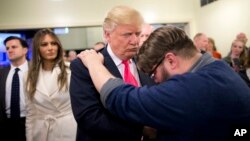 FILE - Pastor Joshua Nink, right, prays for Republican presidential candidate Donald Trump, after a Sunday service at First Christian Church, in Council Bluffs, Iowa.