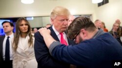 Pastè Joshua Nink (adwat) ki tap priye pou kandida Pati Repibliken an, Donald Trump, aprè yon sèvis relijye nan First Christian Church (Premyè Egliz Kretyèn), nan Council Bluffs, Eta Iowa, nan kòmansman kanpay elektoral la. (Foto Achiv.- Dat: Dimanch 31 Janvye 2016).