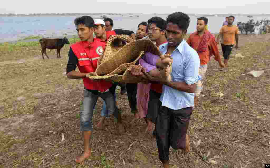 Rescue workers carry the body of a victim of a ferry that capsized in Meghna River, Bangladesh, Feb. 8, 2013.