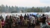 Des réfugiés se tiennent dans un camp de déplacés à l'extérieur de la ville de Bunia, dans la province d'Ituri, le 21 juin 2019.