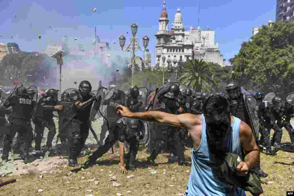 Riot police clash with demonstrators protesting against proposed pension reforms outside the Congress in Buenos Aires , Argentina.