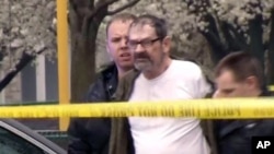 In this Sunday, April 13, 2014 image from video provided by KCTV-5, Frazier Glenn Cross, also known as Frazier Glenn Miller, is escorted by police in an elementary school parking lot in Overland Park, Kansas.