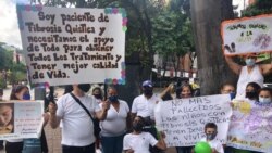 Pacientes con fibrosis quística y sus familiares sostienen su pancartas durante una protesta en Caracas, en octubre de 2021.