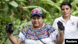 FILE - Guatemalan indigenous rights activist and Nobel Peace Prize winner Rigoberta Menchu shows her hands covered with oil at the Aguarico 4 oil well in Shushufindi, June 3, 2015. Menchu visited the oil well, located in Ecuador's Amazon region Lago Agrio, to view damage supposedly caused by the oil exploration of Chevron-Texaco. 