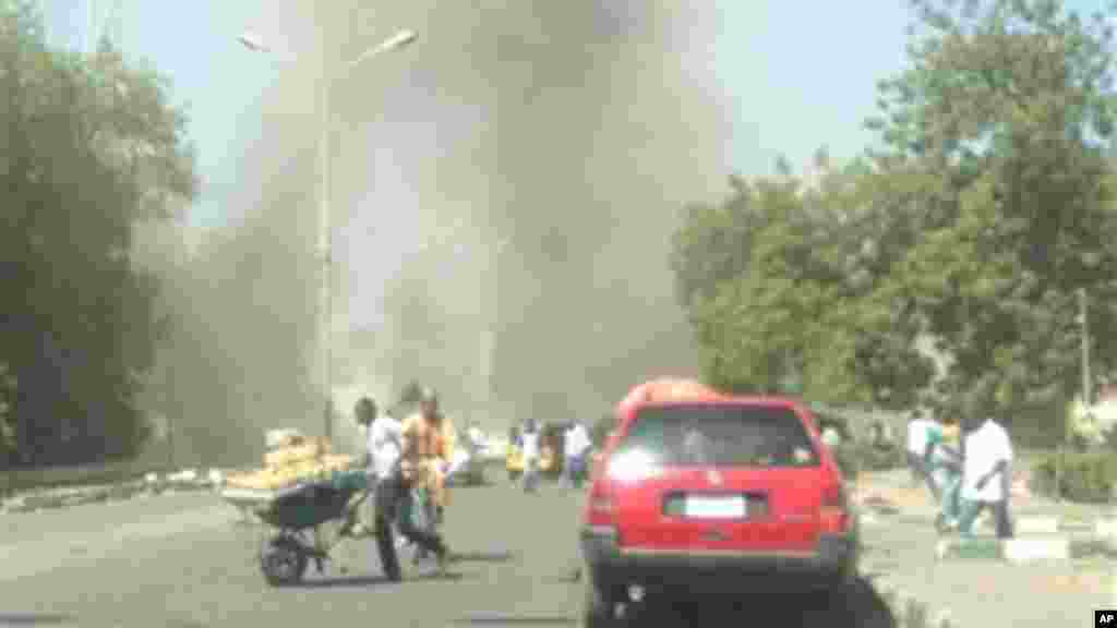 Mutane suna gudu yayin da hayaki ke shiga cikin samaniya bayan da bom ya fashe a inda sojoji ke girke a garin Maiduguri, Junairu 14, 2014.