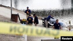 Agentes del FBI preparan equipo de buceo para buscar en el lago del parque Seccombe, en San Bernardino, California.