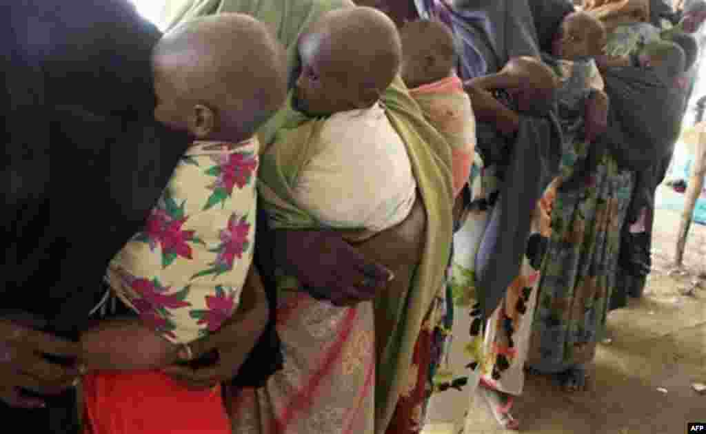 Somali women carrying their malnourished children in a refugee camp for internally displaced people in Mogadishu, Somalia, Thursday, July 28 2011. Heavy fighting erupted Thursday in Somalia's capital as African Union peacekeepers launched an offensive aim