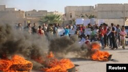 FILE - People gather near burning tires during a demonstration against forces loyal to Syria's president Bashar al-Assad and calling for aid to reach Aleppo near Castello road in Aleppo, Syria, Sept. 14, 2016.