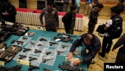 Confiscated weapons are displayed on a table during a news conference at Royal Thai Police headquarters in Bangkok, Oct. 28, 2015. Police widened a major probe into a network of people charged with insulting the monarchy.