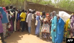 FILE- Cameroonian internally displaced queue at a camp in Kolofata, in the extreme north of Cameroon, for a food distribution provided by the International Red Cross Committee (ICR) on Feb. 22, 2017.
