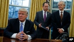 白宫全国贸易委员会主任彼得·纳瓦罗（Peter Navarro，右）等待川普总统签署政令（2017年1月23日）