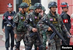 FILE - Soldiers patrol around the Royal Thai Army Headquarters as members of the Radio and Satellite Broadcasters gather in Bangkok, June 18, 2014.
