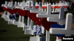 FILE - A photograph hangs from one of the 58 white crosses set up for the victims of the Route 91 music festival mass shooting in Las Vegas, Nevada, Oct. 5, 2017.