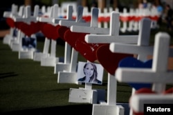 A photograph hangs from one of the 58 white crosses set up for the victims of the Route 91 music festival mass shooting in Las Vegas, Nevada, Oct. 5, 2017.