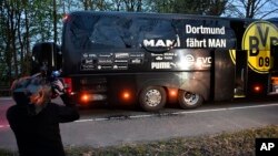 Un homme filme le bus de l'équipe de Dortmund après une explosion qui visait les joueurs, en Allemagne, le 11 avril 2017.