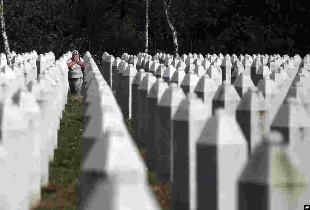 A Bosnian Muslim woman reacts as she walks among gravestones at the memorial center of Potocari near Srebrenica, 150 kilometers northeast of Sarajevo, Bosnia.