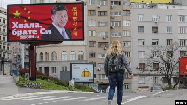 塞尔维亚一名女子走过贝尔格莱德街头树立的感谢中国领导人习近平的广告牌旁。(2020年4月1日)