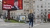 塞尔维亚一名女子走过贝尔格莱德街头树立的感谢中国领导人习近平的广告牌旁。（2020年4月1日）