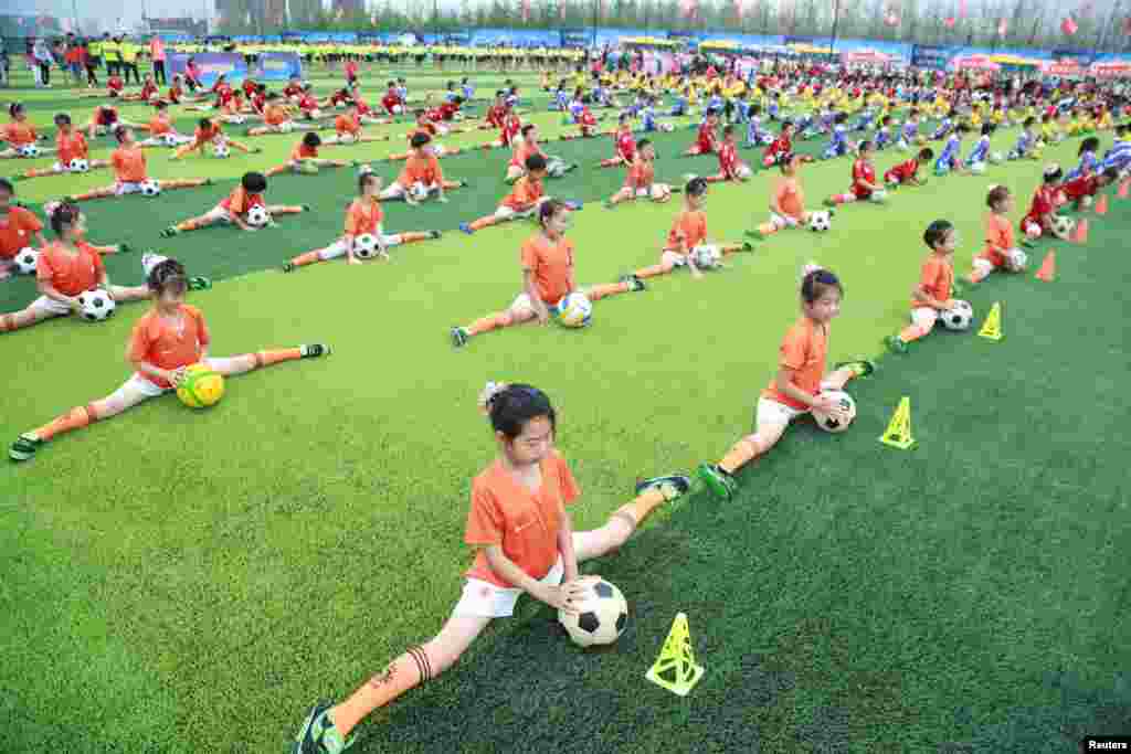 Students perform with soccer balls during an opening ceremony of a soccer event, in Dalian, Liaoning province, China, July 16, 2016.
