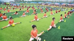 2016年7月16日，在辽宁省大连市的一个足球活动开幕仪式上，学生们进行足球表演。