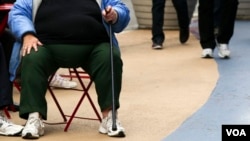 An overweight woman sits on a chair in Times Square in New York, May 8, 2012