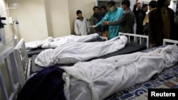 Paramedics and families stand near victims of a bomb attack in a Shi'ite Muslim area, at a hospital in Quetta, Feb. 16, 2013. 