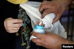 A Jordanian woman puts her finger into an ink bottle after casting her ballot at a polling station for municipal elections in Amman, Jordan, Aug. 15, 2017.