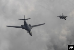 In this photo provided by S. Korea Defense Ministry, a U.S. Air Force B-1B bomber, left, flies with a South Korean fighter jet F-15K over the Korean Peninsula, South Korea, July 30, 2017.