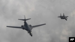 Dalam foto yang dirilis Departemen Pertahanan Korea Selatan, sebuah pesawat Angkatan Udara AS B-1B bomber (kiri), terbang dengan pesawat tempur Korea Selatan F-15K di atas semenanjung Korea Selatan, 30 Juli 2017.