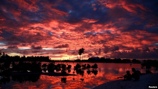 太平洋中部岛国基里巴斯，村民们在一个小湖旁看日落（2013年5月25日）。