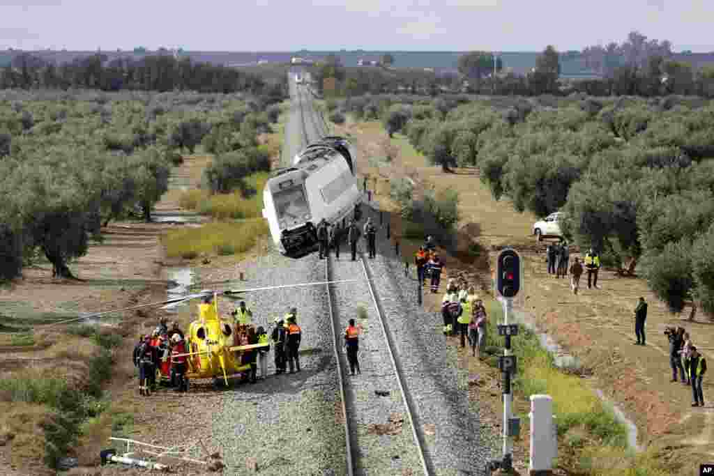 A train carriage is seen derailed near the town of Arahal, in the Seville province, Spain. Spanish officials said 27 people were injured when a train carriage derailed after part of a track became flooded between the southern cities of Malaga and Seville.