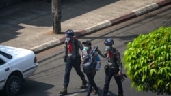 FILE - Police arrest a journalist in Yangon on February 27, 2021, as protesters were taking part in a demonstration against the military coup.
