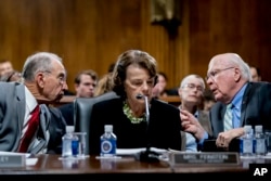 Senate Judiciary Committee Chairman Chuck Grassley, R-Iowa, left, accompanied by Sen. Dianne Feinstein, D-Calif., the ranking member, center, speaks with Sen. Patrick Leahy, D-Vt., right, during a Senate Judiciary Committee markup meeting on Capitol Hill.