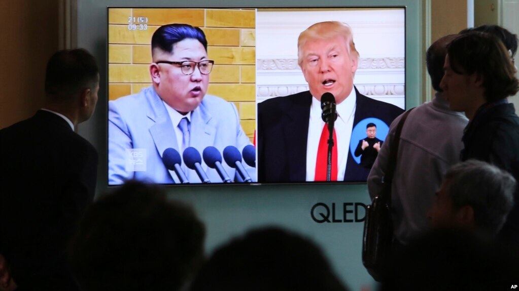 People watch a TV screen showing file footage of U.S. President Donald Trump, right, and North Korean leader Kim Jong Un during a news program at the Seoul Railway Station in Seoul, South Korea, April 21, 2018. 