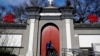 一名男子在北京一家天主教堂大门外从门缝向内窥视。(资料照片)