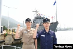 안희현 소령(왼쪽·해사57기)과 안미영 소령(사후98기)이 18일 해군함정 앞에서 화이팅을 외치고 있다. (해군본부 제공)