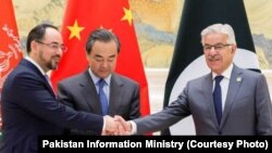 Pakistani Foreign Minister Khawaja Asif shakes hand with Afghan Foreign Minister Salahuddin Rabbani in Beijing, Dec. 26, 2017.