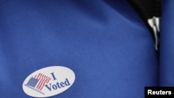 A sticker is attached to a voter's jacket during the U.S. presidential election at the School Without Walls polling station in Washington, November 6, 2012. REUTERS/Yuri Gripas (UNITED STATES - Tags: POLITICS USA PRESIDENTIAL ELECTION ELECTIONS)