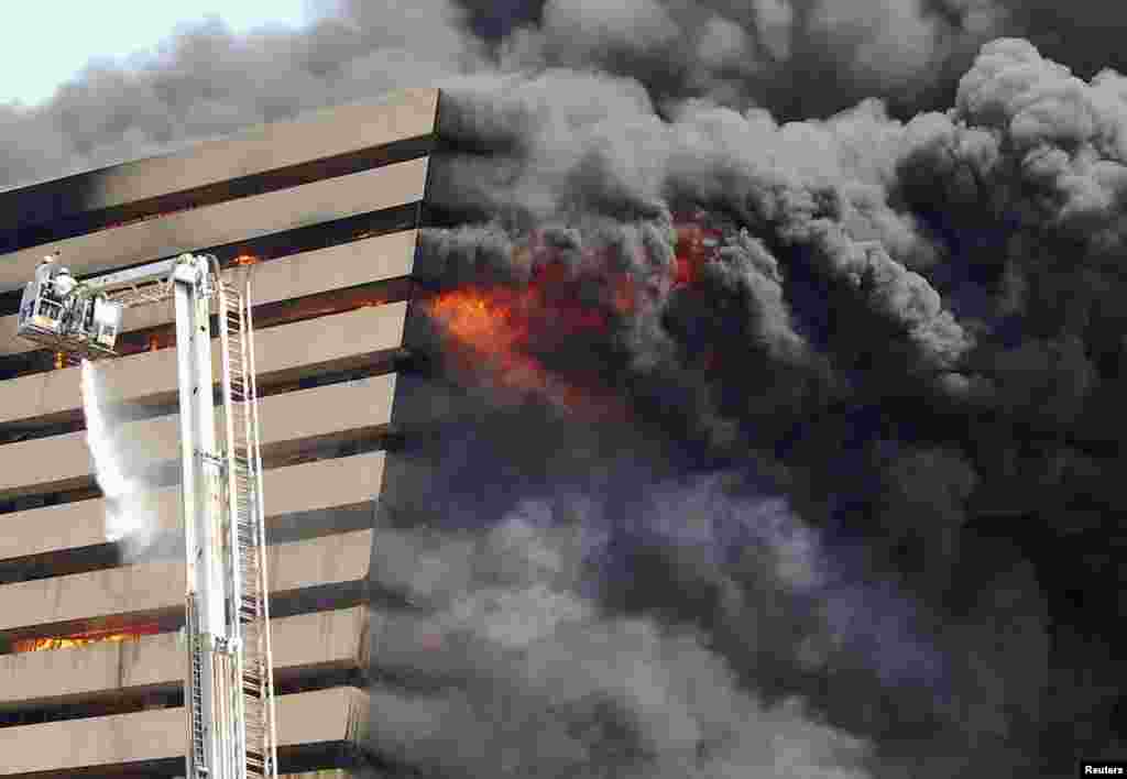 Firefighters try to douse the flames after a fire broke out in a commercial building at a textile market in Surat in the western Indian state of Gujarat. The cause of the fire is being investigated and no causality is reported, fire officials said.