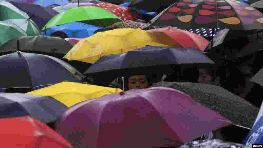Participants for "Walk for Peace" use umbrellas in the rain brought on by Typhoon Kalmaegi, also called Luis, at Luneta park in Manila, Philippines, Sept. 14, 2014.