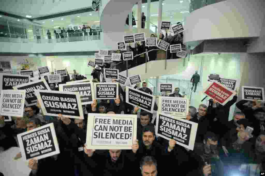 People gather to support those held by police after raids in a dozen cities, detaining around 20 people including journalists and television producers, inside the headquarters of Zaman newspaper in Istanbul, Turkey, Dec. 14, 2014.