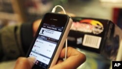 FILE - A man uses his smartphone to help him find the right gifts and compare prices at a retail store in New York.