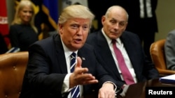 Homeland Security Secretary John Kelly, right, listens to U.S. President Donald Trump during a meeting with cybersecurity experts in the Roosevelt Room of the White House in Washington, Jan. 31, 2017.