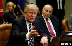 Homeland Security Secretary John Kelly, right, listens to U.S. President Donald Trump during a meeting with cybersecurity experts in the Roosevelt Room of the White House in Washington, Jan. 31, 2017.