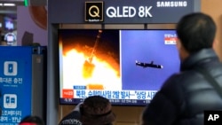 Transeúntes observan imágenes de archivo de un lanzamiento de misiles norcoreano durante un programa de noticias en una estación de trenes de Seúl, Corea del Sur, el martes 25 de enero de 2022.