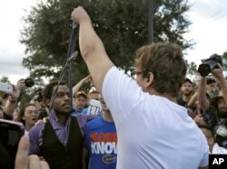 A supporter of white nationalist Richard Spencer grabs ahold of a protester's tie during a clash after a speech by Spencer, Oct. 19, 2017, at the University of Florida in Gainesville, Fla.