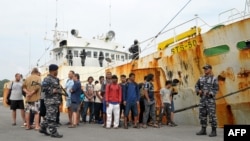 Tentara Indonesia mengawal anak buah kapal di samping kapal yang diduga sebagai “kapal budak” di pelabuhan Angkatan Laut di Sabang, 7 April 2018, menyusul pengejaran dramatis di laut bergelombang tinggi. Kapal ditangkap sekitar 60 mil dari Pulau Weh, Aceh.