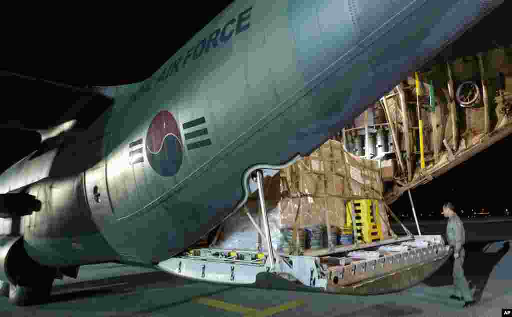 Seorang tentara Korea Selatan memeriksa barang-barang bantuan di atas pesawat kargo C-130 milik Angkatan Udara Korea Selatan sebelum terbang ke bandara Tacloban, Filipina, di bandara militer Seoul di Seongnam, Korea Selatan (14/11). (AP/Lee Jin-man)