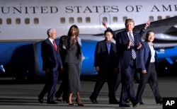 FILE - President Donald Trump walks with Tony Kim, third right, Kim Dong Chul, right, and Kim Hak Song, behind Trump, the three Americans detained in North Korea, as they arrive at Andrews Air Force Base in Md., May 10, 2018. Walking with Trump is Vice President Mike Pence.