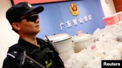 Một cảnh sát canh gác bên cạnh lô hàng ma túy bị thu giữ ở Trung Quốc năm 2018. Bộ Công an Việt Nam đã phát hiện và đang điều tra đường dây sản xuất ma túy của người Trung Quốc ở Việt Nam, trong đó 4 người Trung Quốc bị phạt "hành chính" 95 triệu đồng. 